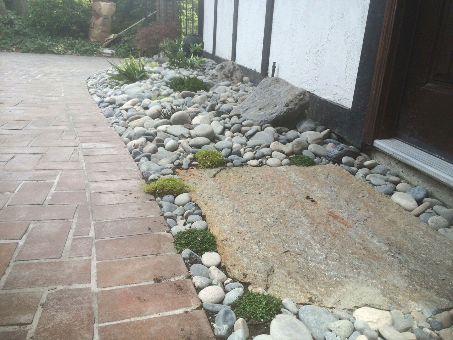 A stone pathway with scattered white rocks beside a building.