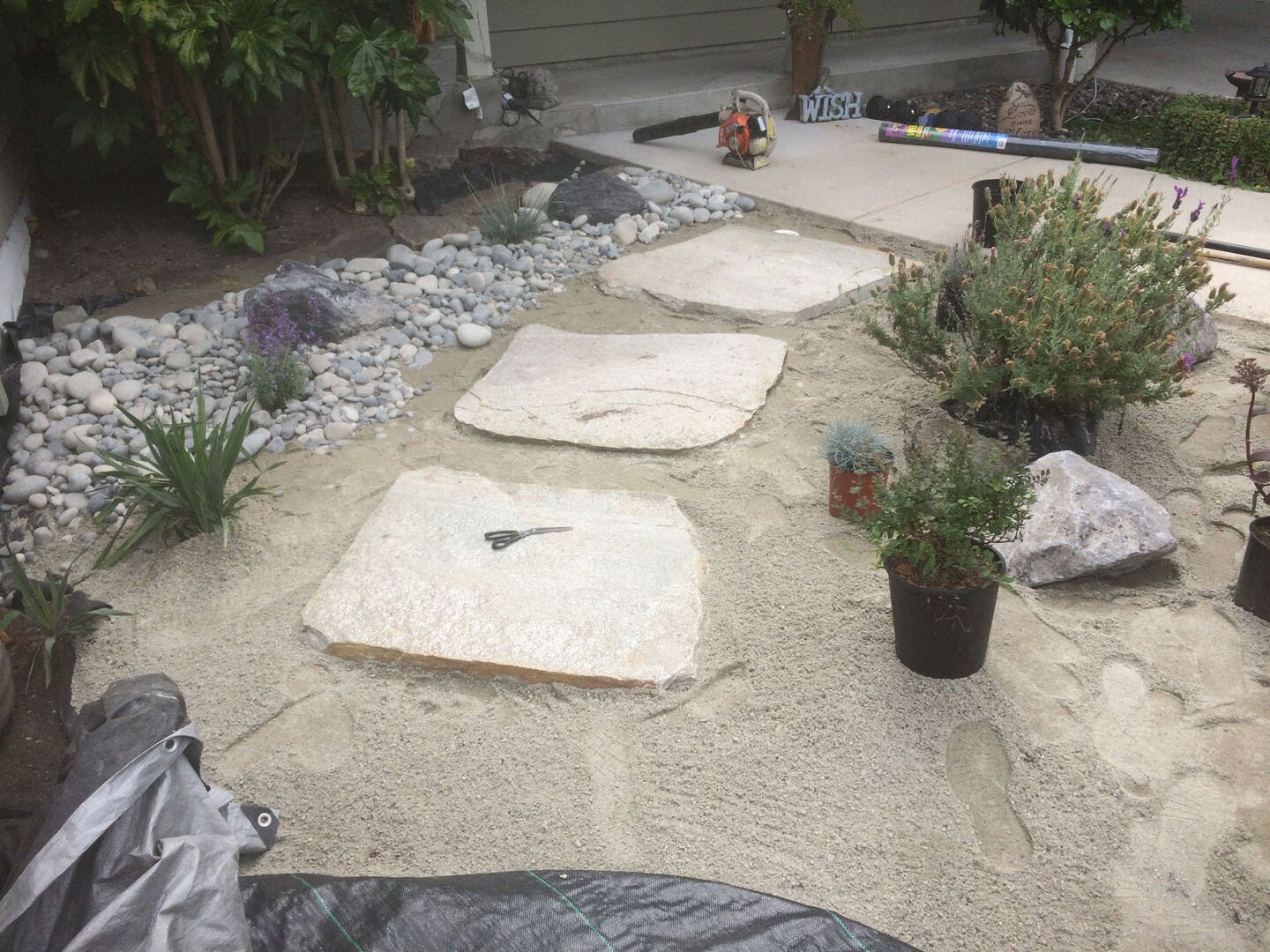 Stone pathway under construction in a garden area.